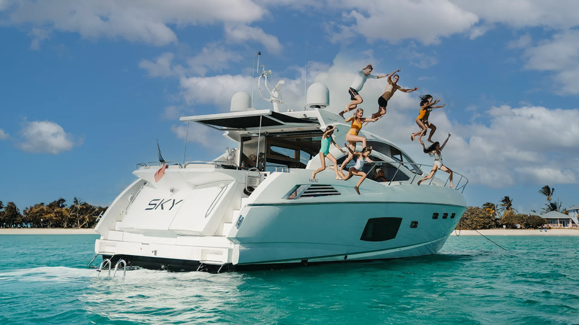 Guests jumping from the Sky 66-foot Sunseeker Predator yacht into the turquoise waters of Anguilla.